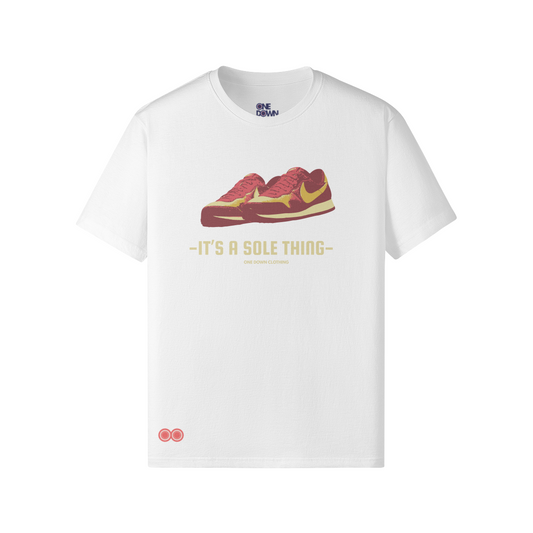 White t-shirt featuring a vintage-style red and yellow Nike Omega Flame sneaker graphic, with the phrase “It’s a Sole Thing” printed beneath in bold retro lettering. A subtle “One Down Clothing” logo sits below the slogan, and a small double-ring logo is placed near the hem. Clean, minimal layout designed for streetwear and football culture fans.